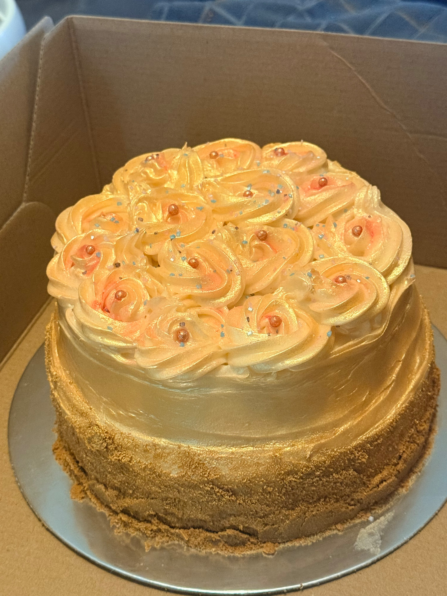 Custom celebration cake decorated with golden rosettes